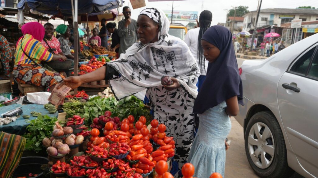 Idowu Bello, 56, buys onions to prepare a pot of soup at a market in Ibadan, Nigeria, Friday, Sept. 13, 2024.