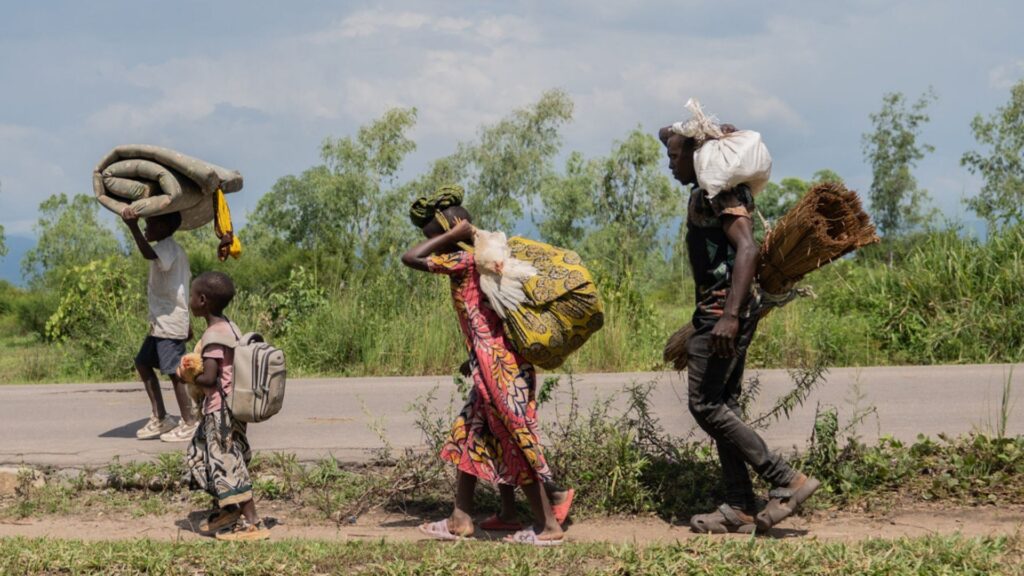 Displaced people who fled the war between FARDC and M23 rebels walk with their belongings as they return to their homes in Luvungi, Democratic Republic of Congo, Saturday, Dec. 13, 2025.