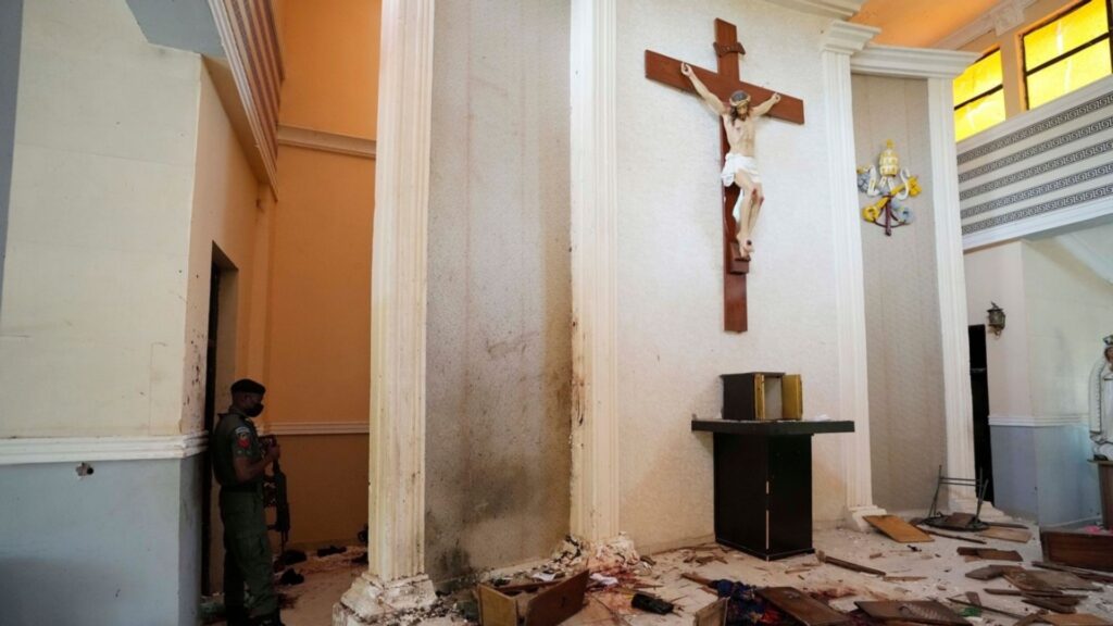 FILE - A police officer stands guard inside the St. Francis Catholic Church, a day after an attacked that targeted worshipers in Owo, Nigeria, June. 6, 2022.