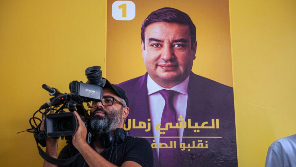 Tunisia pardons former presidential candidate Ayachi Zammel A cameraman films a press conference held by Abdessatar Messaoudi, attorney of Tunisian presidential candidate Ayachi Zammel, seen on the poster on the wall, after Zammel was sentenced to prison on fraud charges that Messaoudi decried as politically motivated, in Tunis, Monday, Sept. 16, 2024